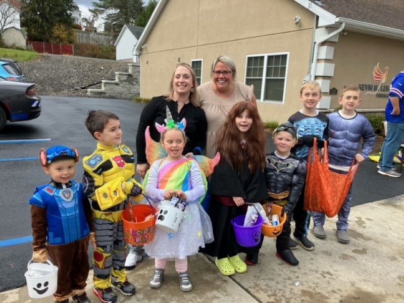 Trick-or-treaters line up on the sidewalk of Forest City, PA