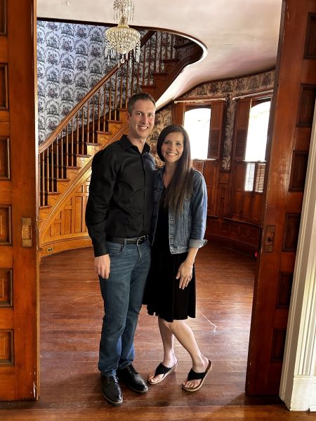 Jon & Denise Ebersole beside the grand staircase in the Metcalf Mansion